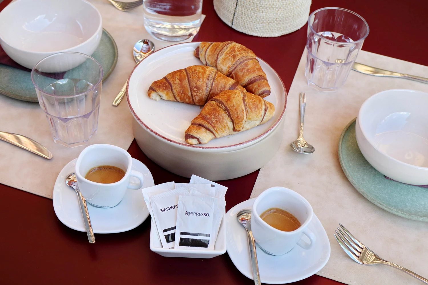 Caffè e cornetti sul tavolo bordeaux apparecchiato per la colazione di The Monteleone