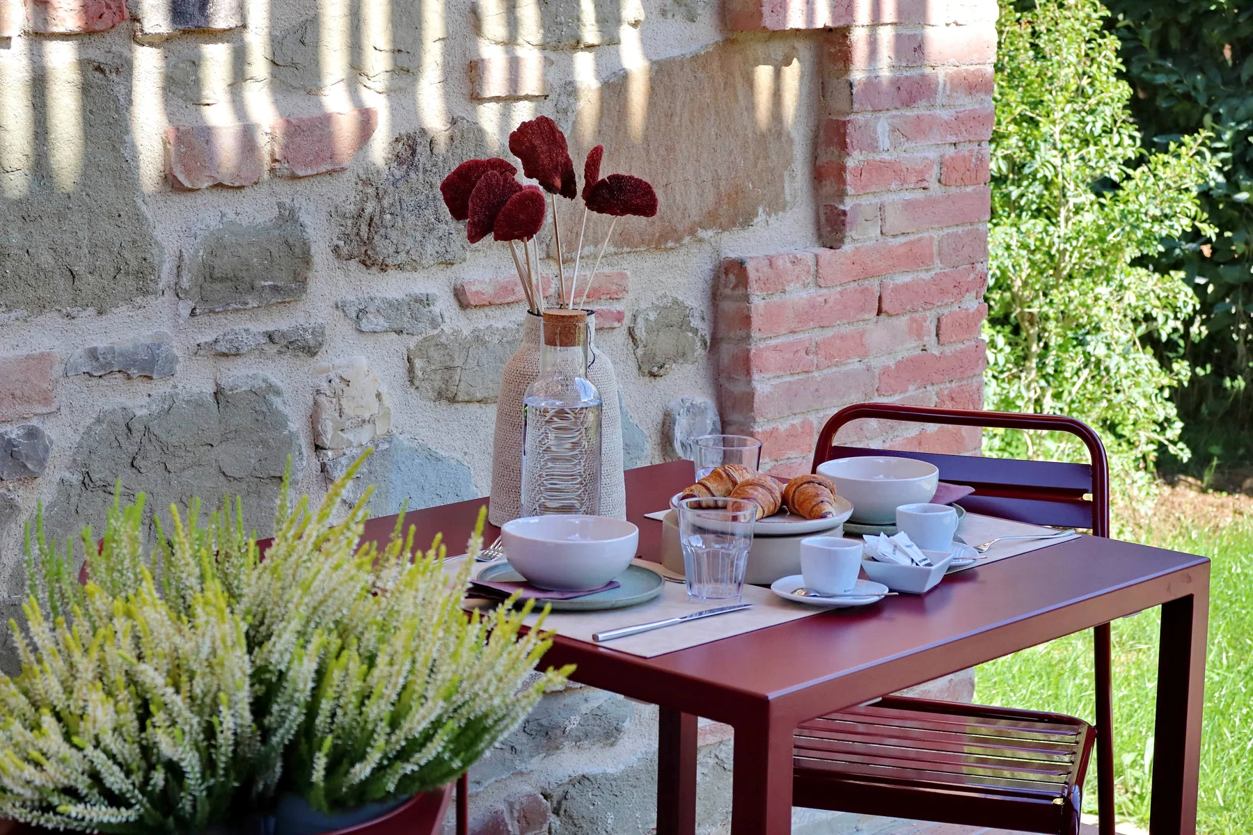 A breakfast table at The Monteleone, with coffee cups and croissants beneath the stone portico