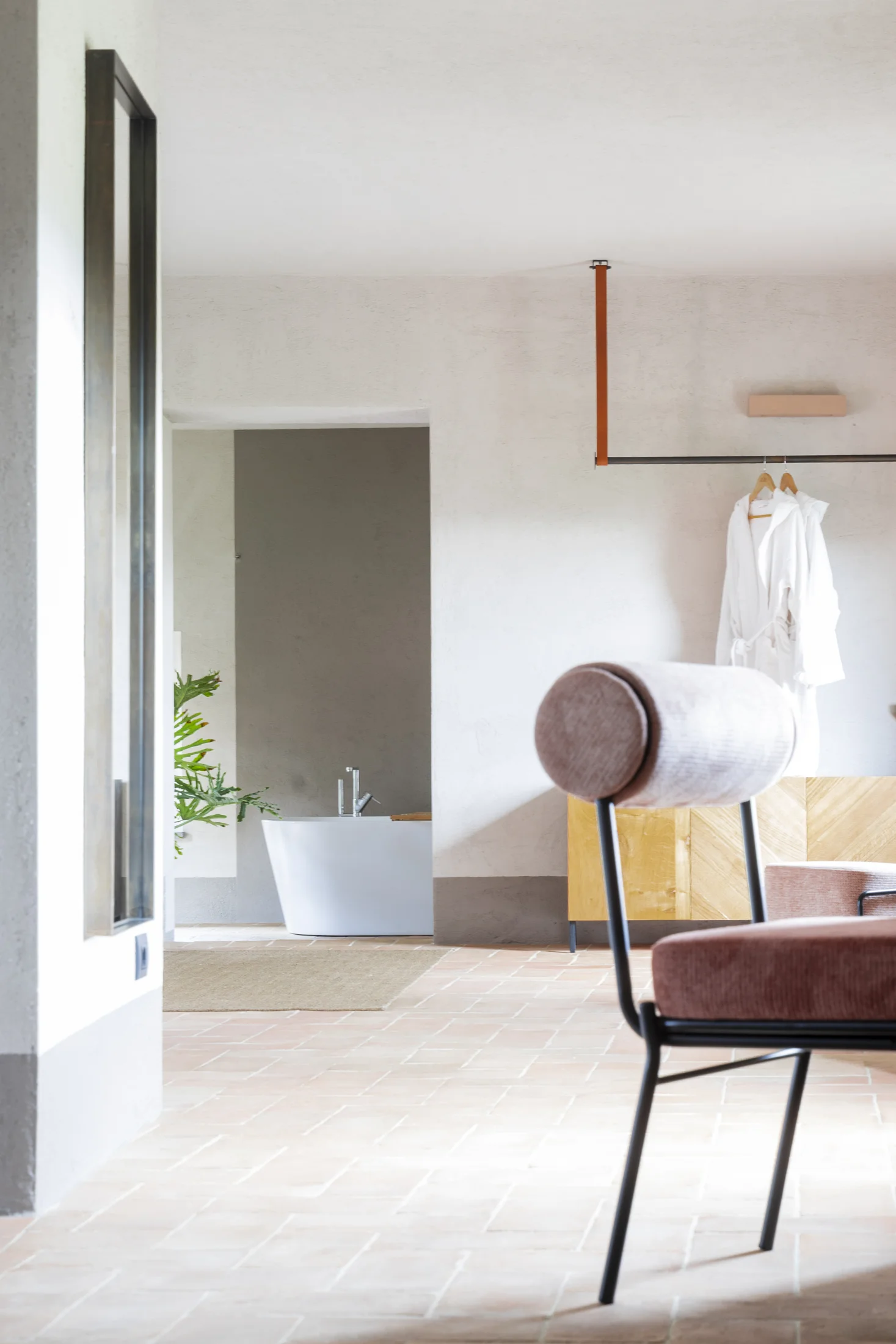 A detail of the suite, with its furnishings, natural light and bathtub