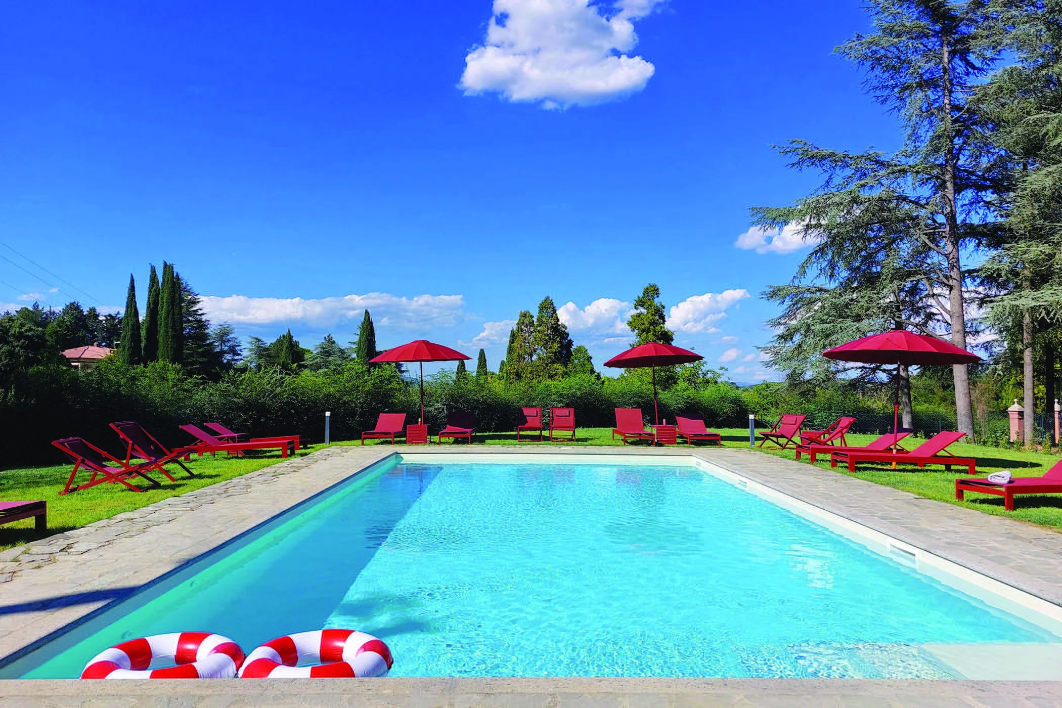The outdoor pool at The Monteleone, surrounded by gardens, with loungers and red parasols